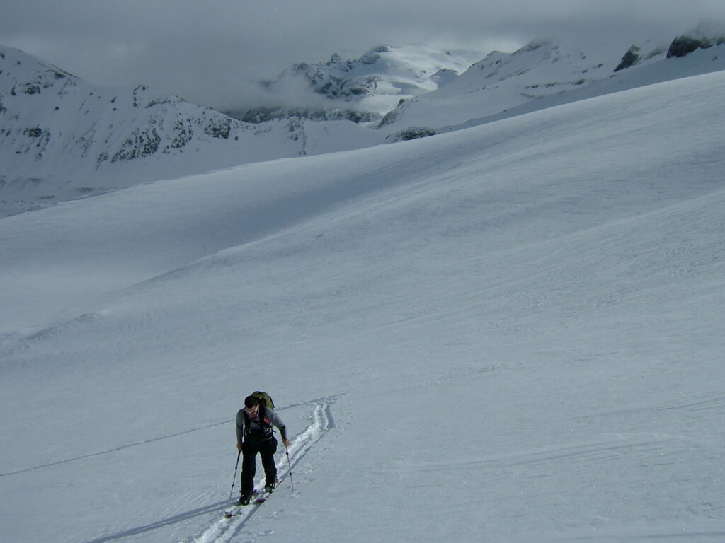 John skinning above the col of Goat Island Mountain and Whitman Crest with the Cowlitz Chimneys in the distance.