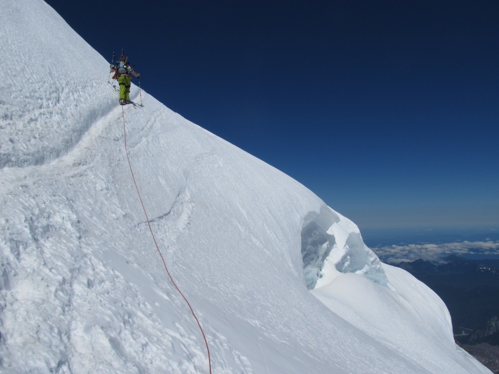 Climbing past a crevasse on the Emmons Glacier in August