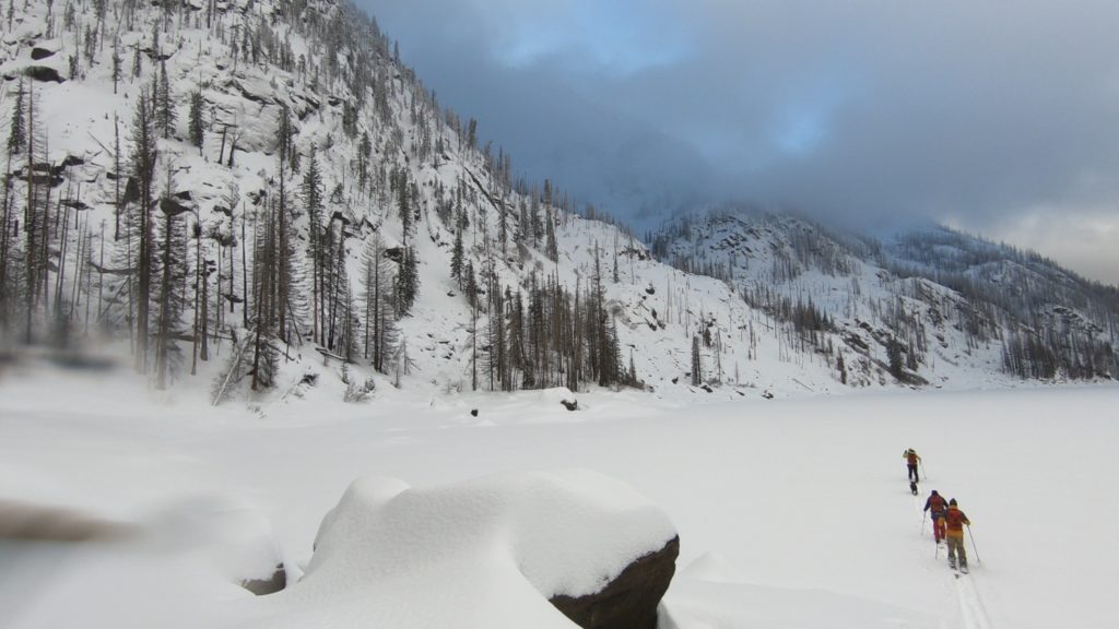 Skinning across Eightmile Lake as it is frozen in the middle of winter