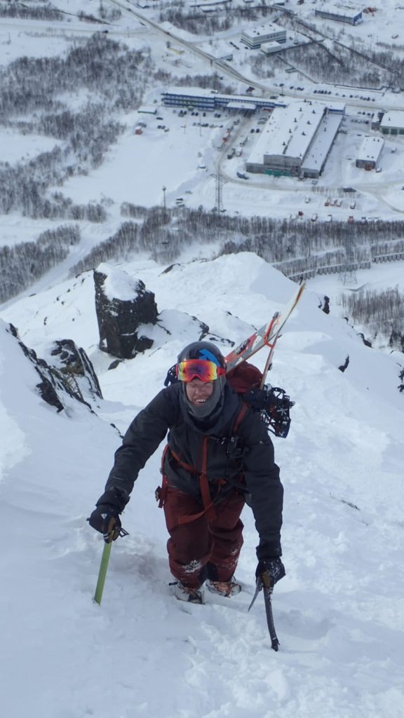 Climbing up the steep face with ice axe in hand