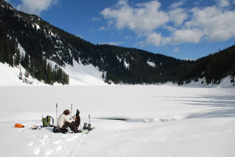 Checking the Map and resting in the sunshine at upper Tuscohatchie Lake during the Alpental to Granite ski traverse