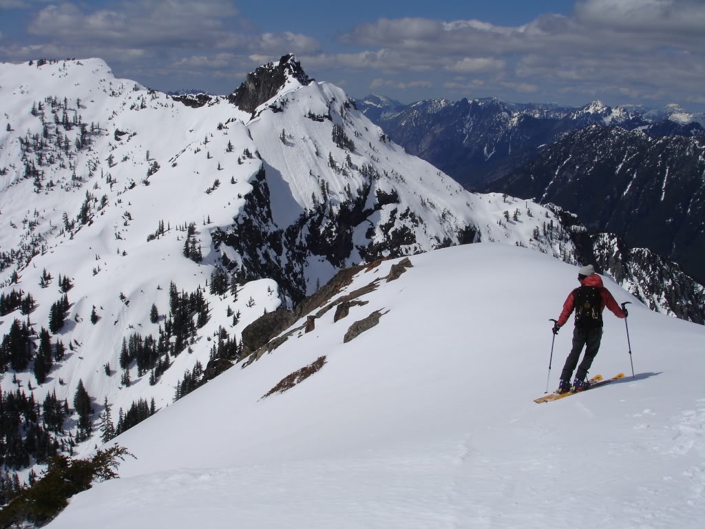 Amar preparing to ski off the summit of Red Peak with Lundin Peak in the background