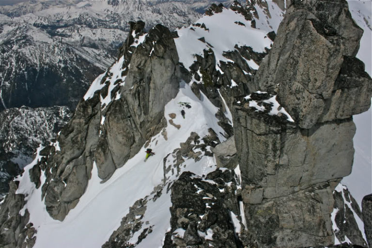 Scott snowboarding off from Dragontail Peak