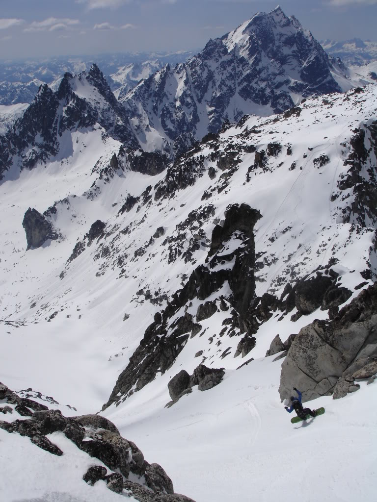 Jeff snowboarding down with Mount Stuart in the distance from Dragontail Peak