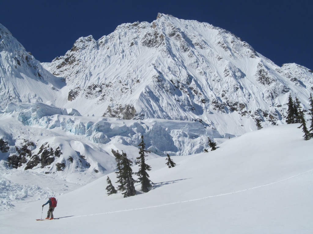 Scott skinning up the lower slopes with the main headwall of Goode Mountain and Goode glacier in the distance