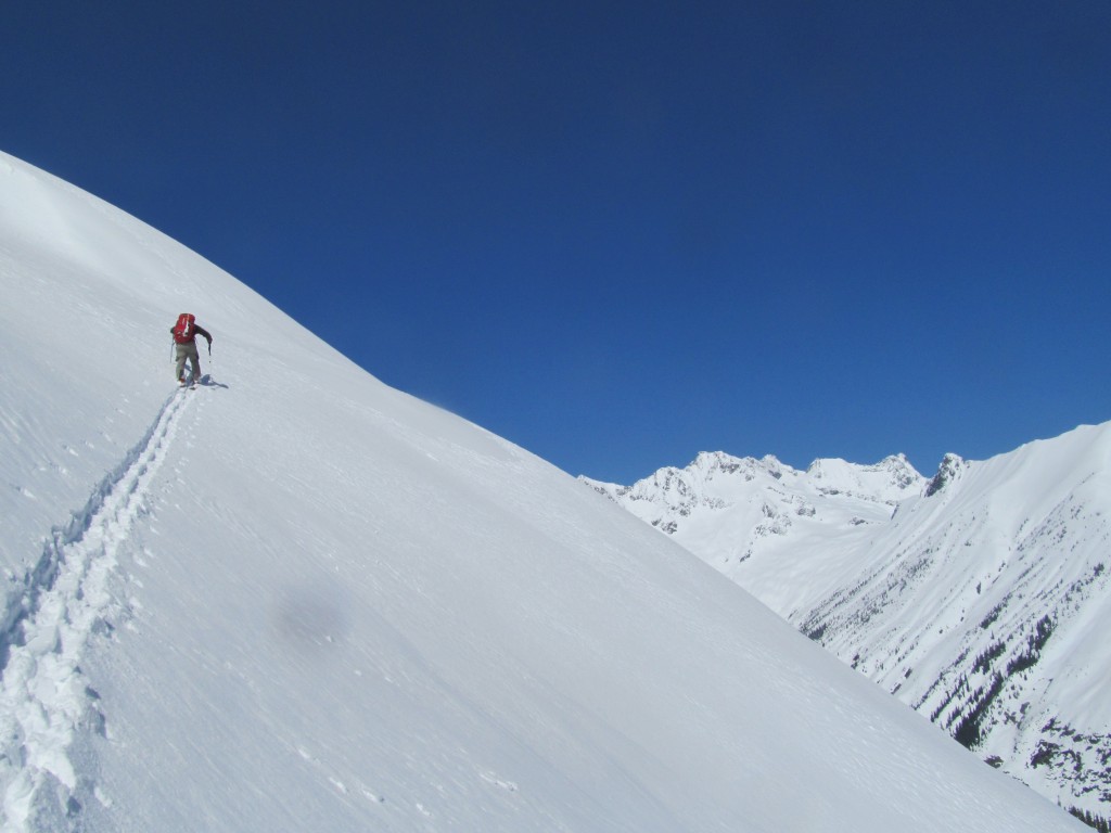 Scott skinning up the steeps with Mount Logan massif in the distance