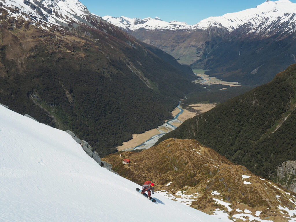 Snowboarding with the Liverpool hut in the distance and the Matukituki valley bellow