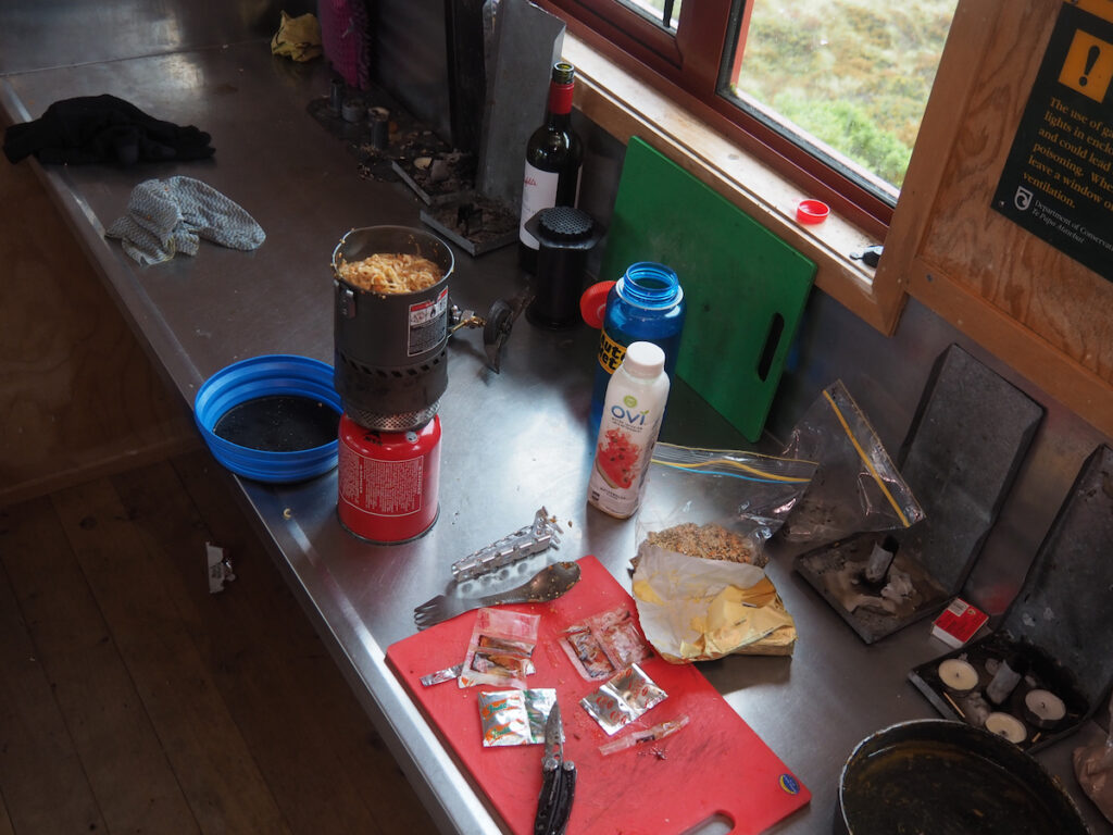 Eating food at the Liverpool Hut after climbing Mount Barff