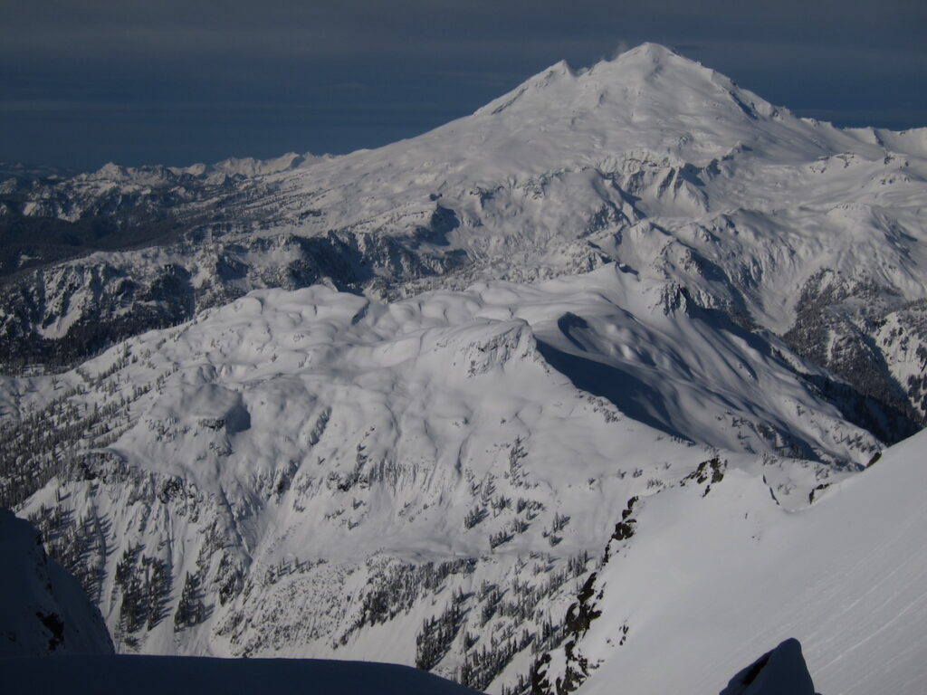 Ski touring up Mount Shuksan with Mount Baker in the distance