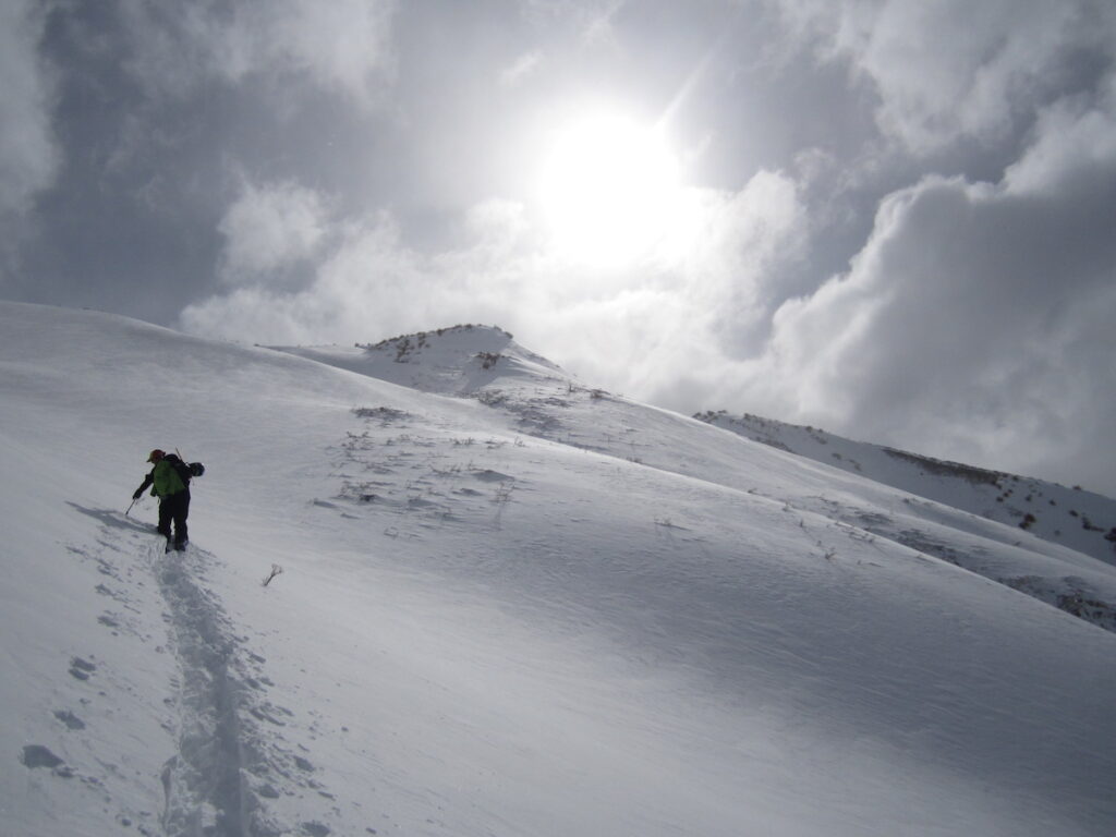 Ski touring up a hill in Las Lenas while snowboarding in Argentiina