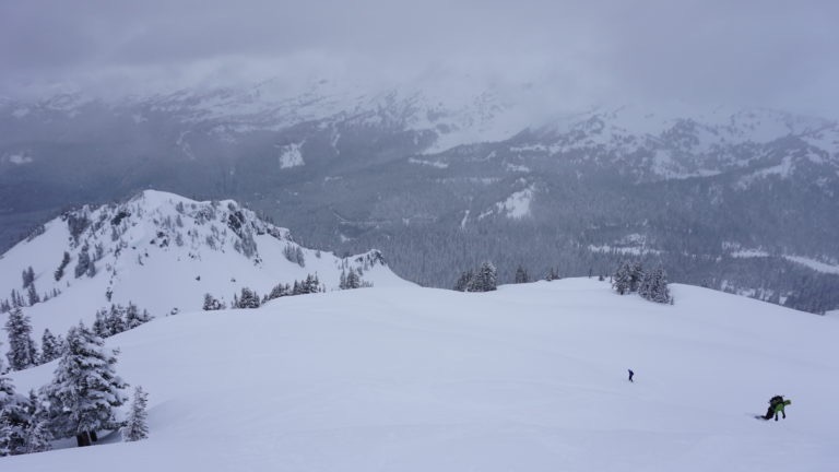 Snowboarding down Plumber Peak before climbing up to Lane Peak Col