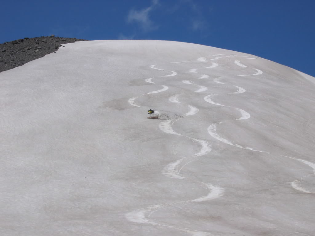 Putting snowboard tracks into dirty snow while backcountry snowboarding Mount Adams