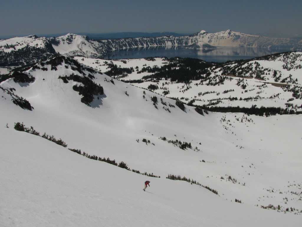 Snowboarding down the west bowl of Mount Scott with Crater Lake in the background