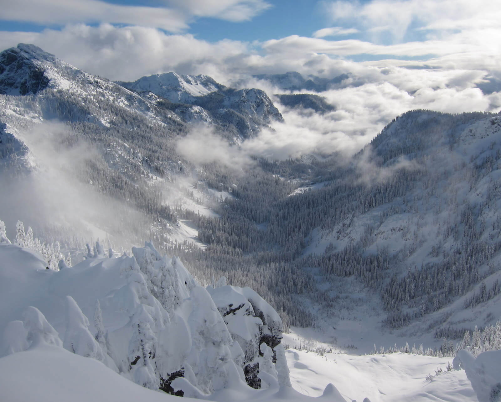 Looking down towards the Alpental Valley in the Snoqualmie Pass Backcountry while ski touring out to Snow Lake