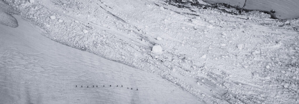 John Scurlock photo of people passing by some avalanche debris and gaining valuable backcountry knowledge