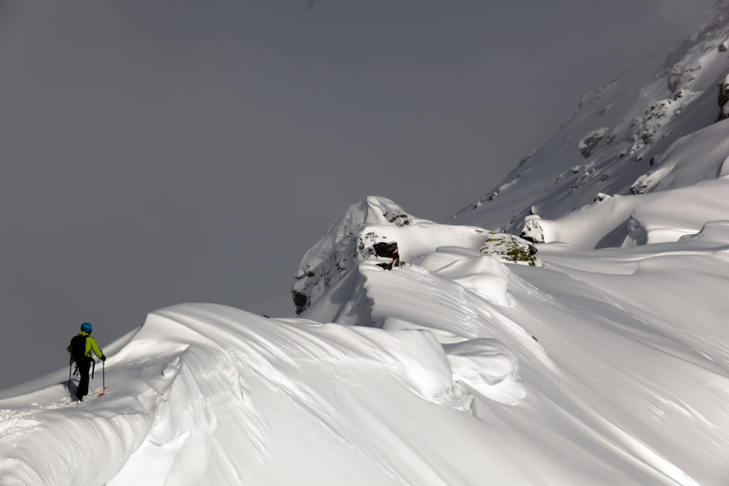 Skinning off a ridge and preparing for a backcountry snowboard descent