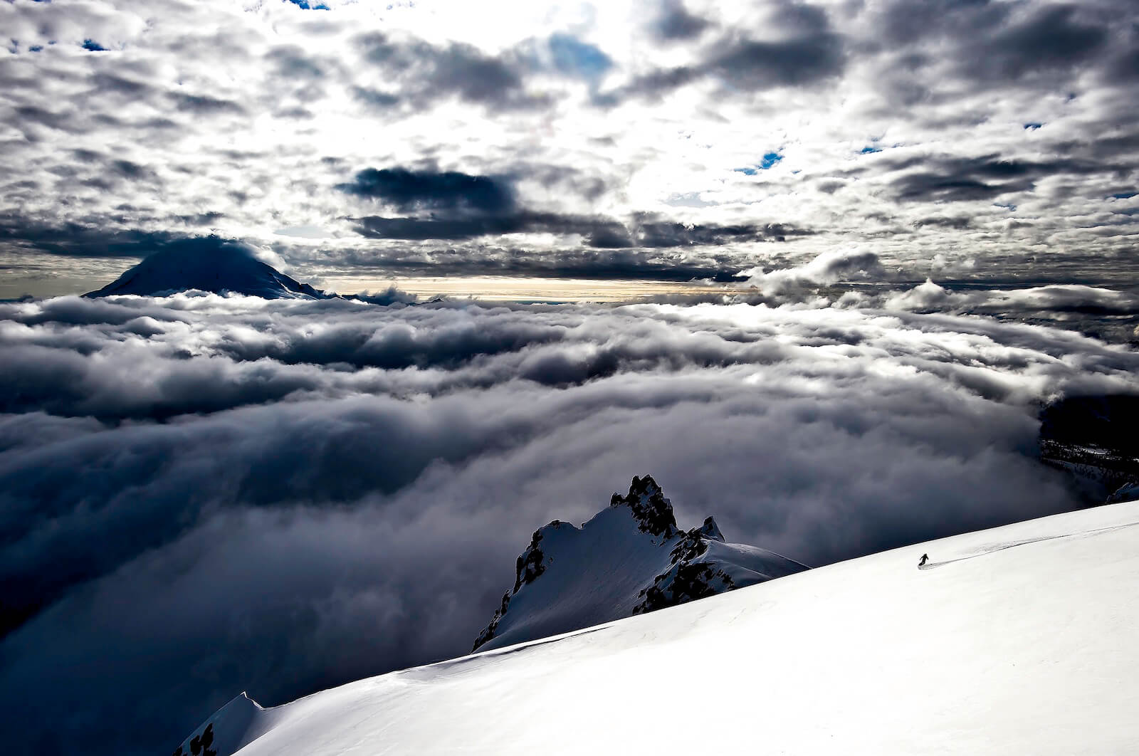 Snowboarding down Mount Shuksan with Mount Baker in the background and a photo representing the ski tours near Highway 542 in the North Cascades of Washington State