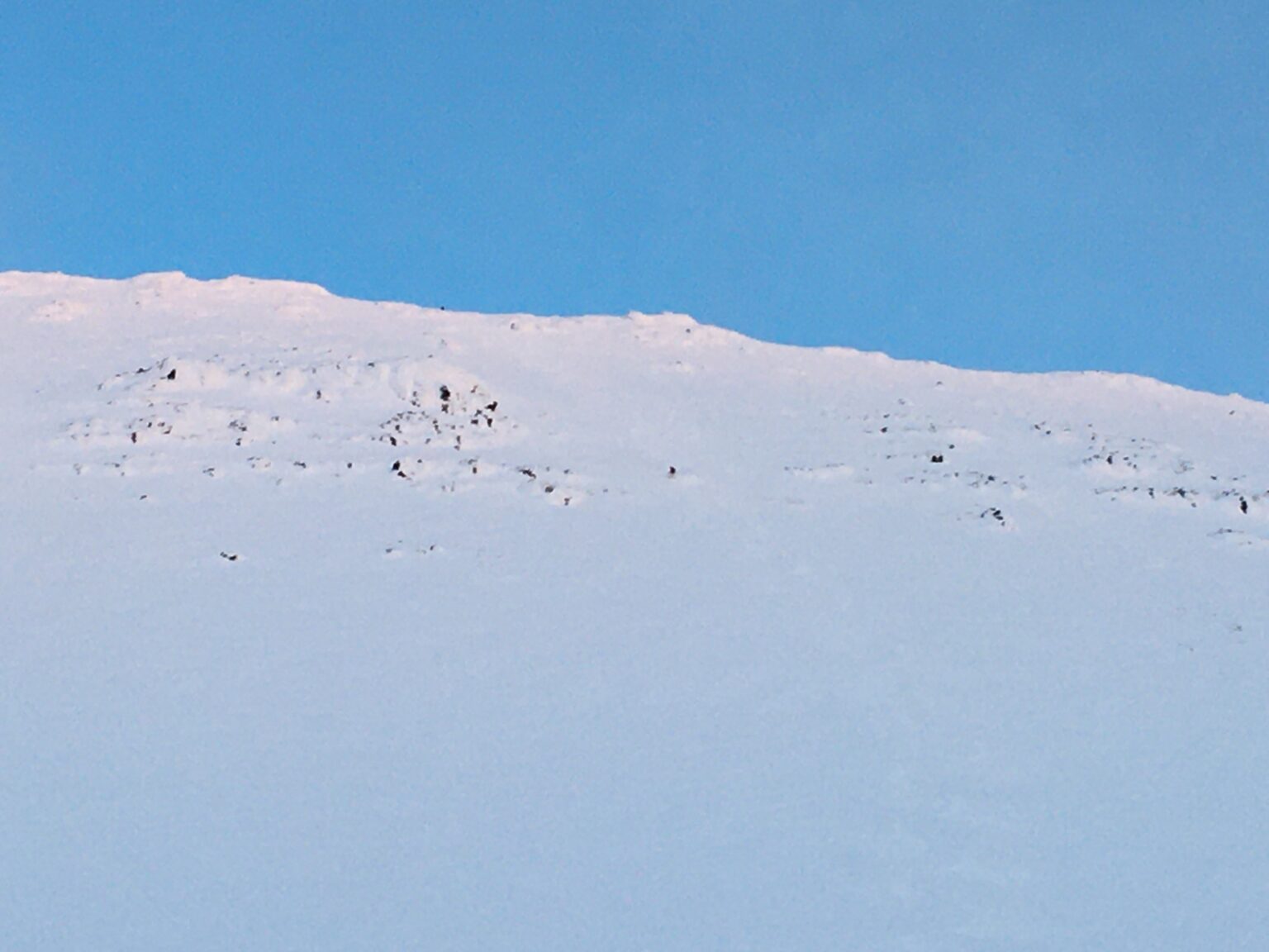 Looking up at the Northern face of Rostakulen as I snowboard down one of the chutes