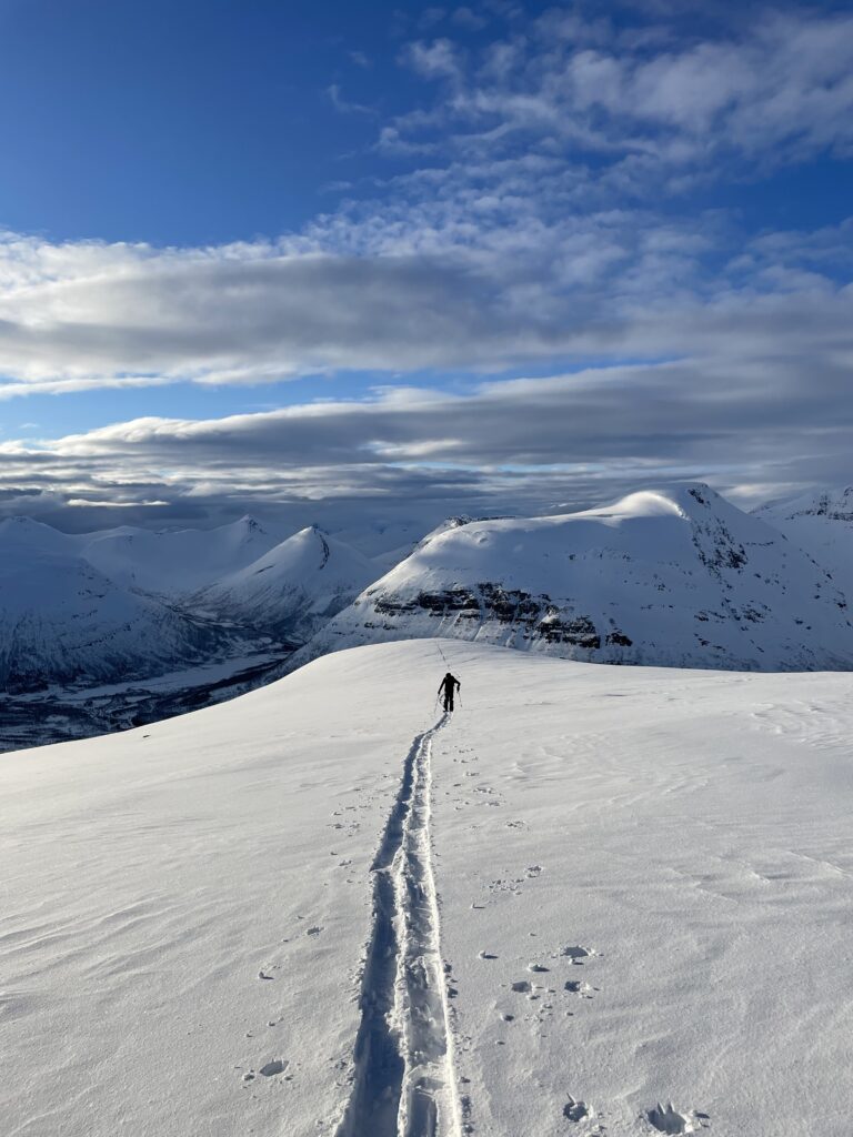 ski touring up Nerotinden with Tamokfjellet in the Background
