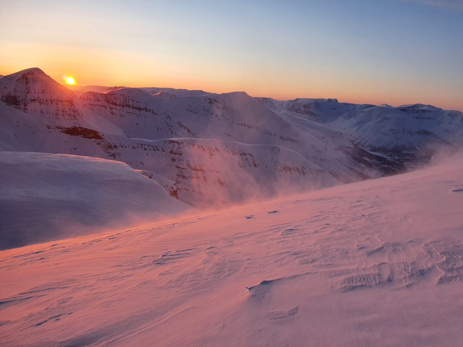 Beautiful sunrise over the Tamokdalen Backcountry in Northern Norway just before snowboarding the South Chute of Háhttagáisi