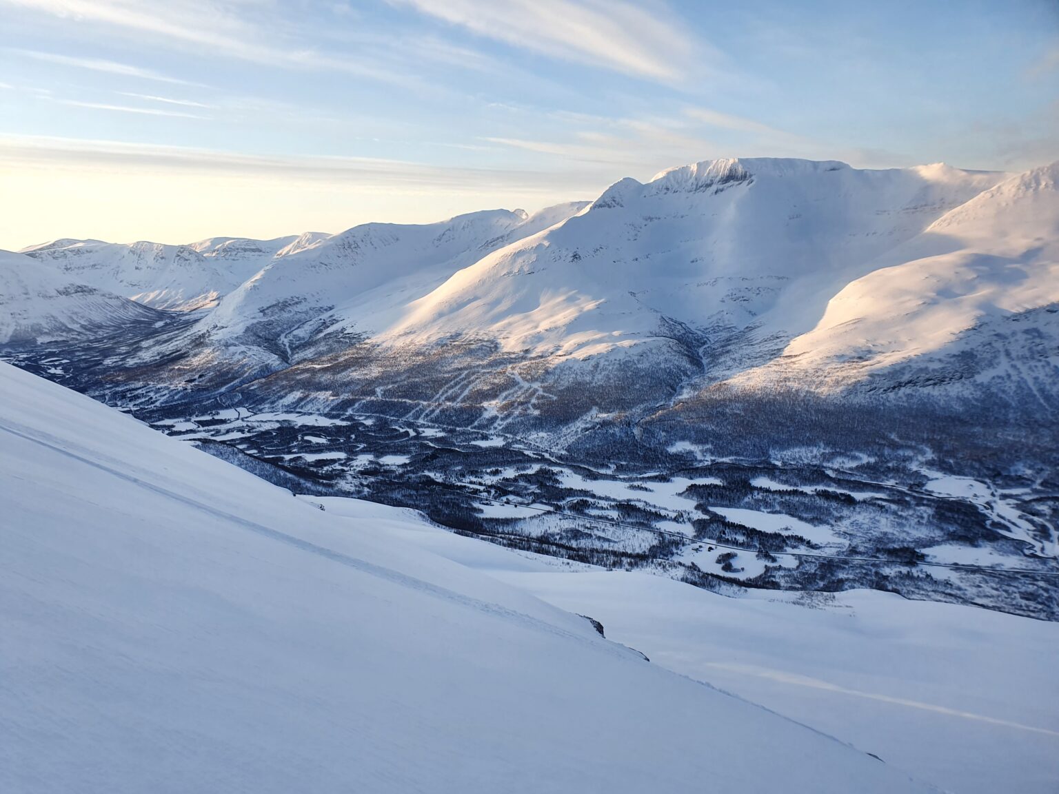 Sunrise over the Tamokdalen Valley after snowboarding the South chute of Háhttagáisi