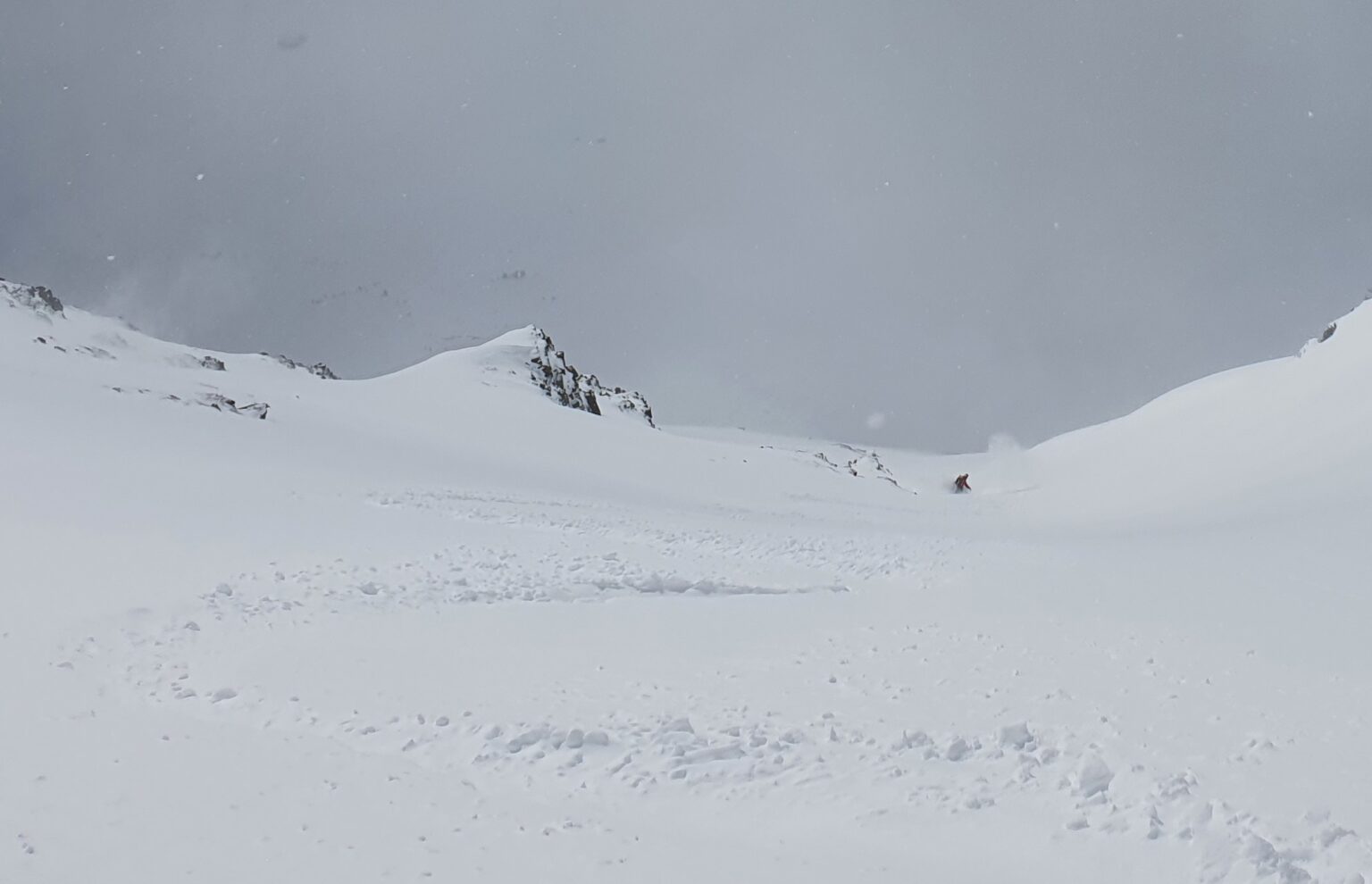 Snowboarding through the crux of the West chute on Sjufjellet in powder conditions