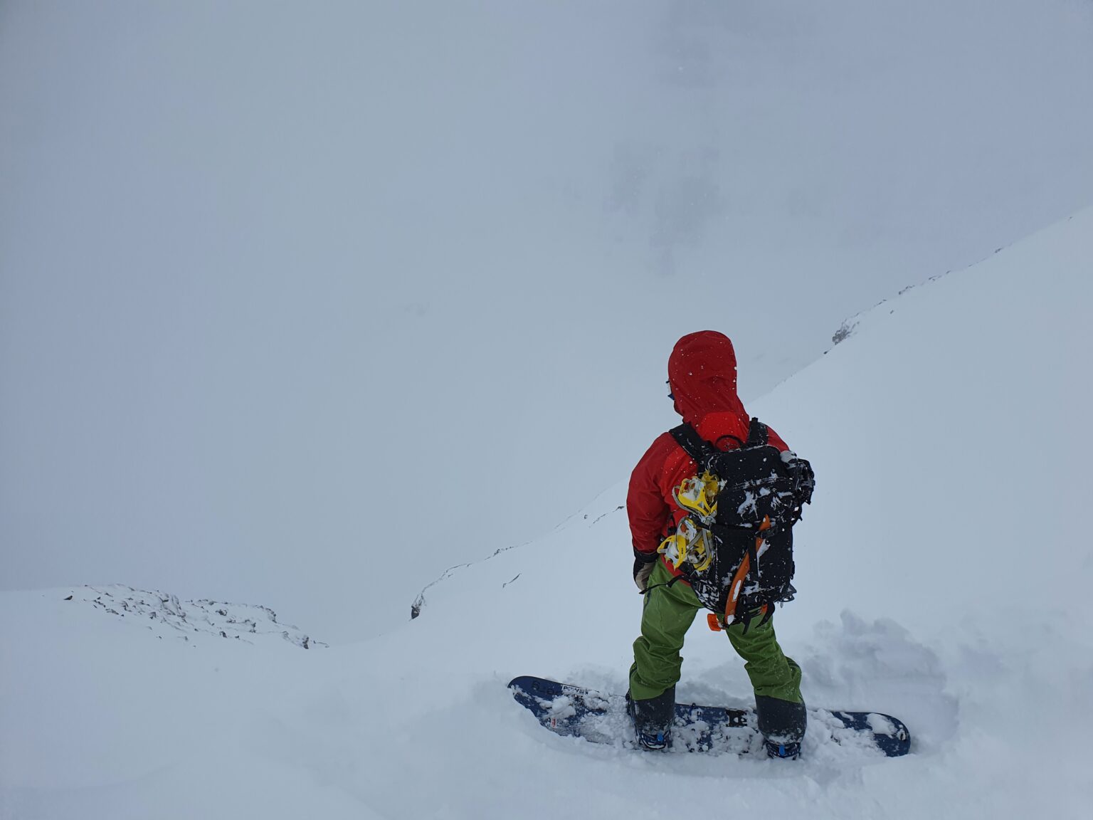 Preparing to snowboard down the West chute of Sjufjellet in the Tamokdalen Backcountry