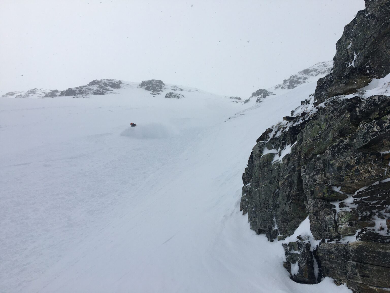 Snowboarding down the West Chute of Sjufjellet in powder conditions