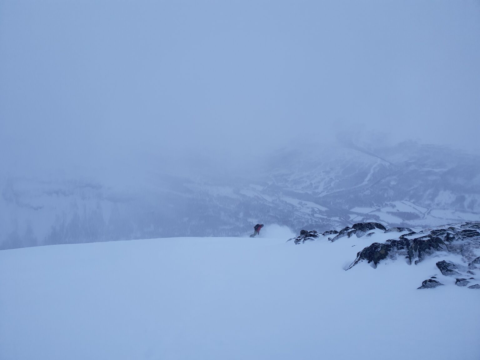 Snowboarding down the South face of Sjufjellet in powder conditions