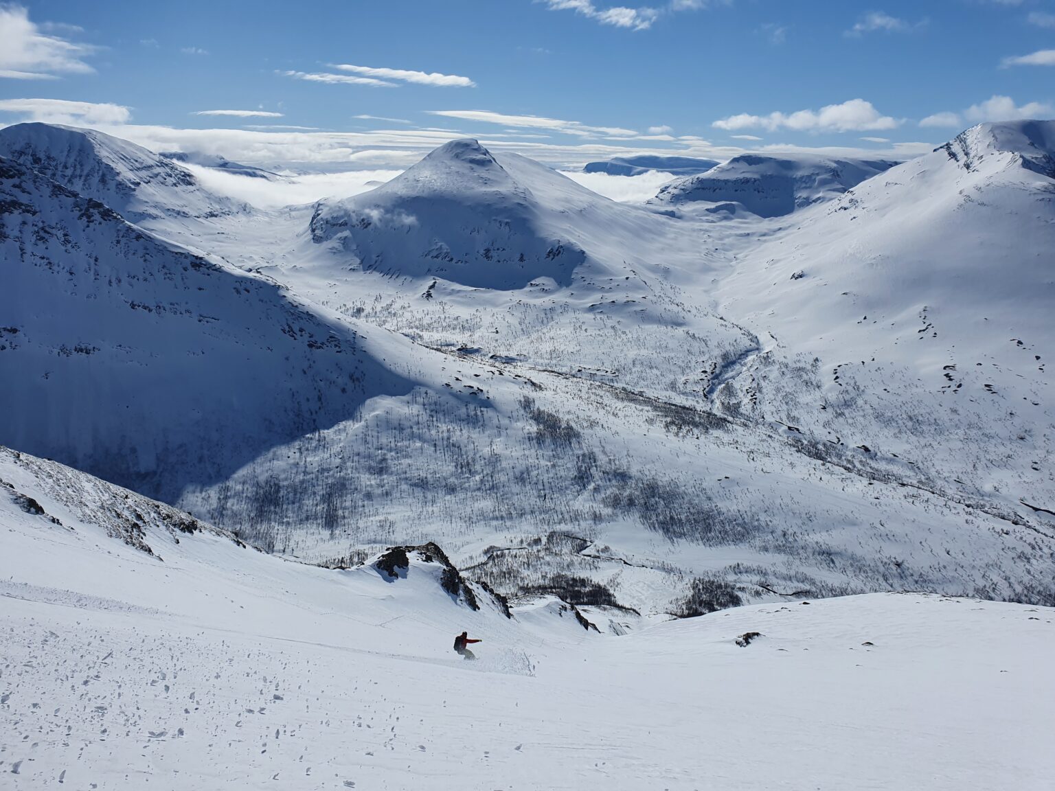 Looking down the entire south chute of Tamokfjellet while snowboarding in powder conditions