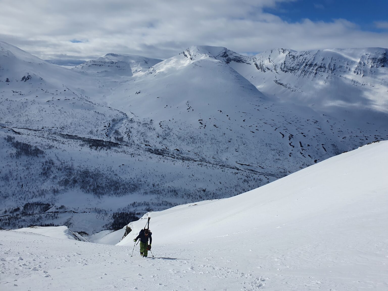 Cramponing past the crux section of the South face of Tamokfjellet with Nerotinden in the background