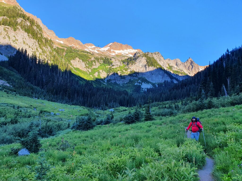 Dan hiking up Spider Meadows as the upper mountains bask in early morning light