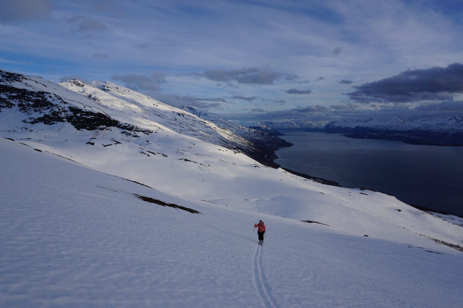 Ski touring up the upper basin of Storhaugen with the Lyngenfjord in the background