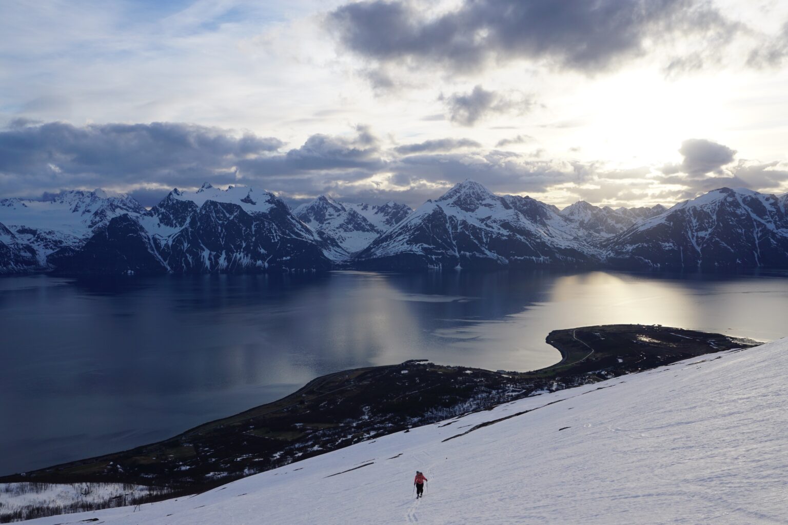 Skinning up the final slopes of Storhaugen with the Lyngen Alps of Norway in the background