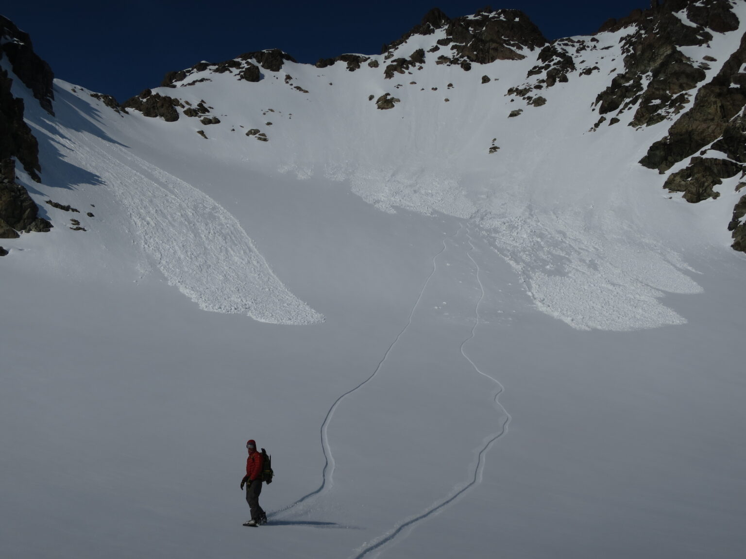 Snowboarding into Tvillingtinden Basin with our snowboard tracks in the distance