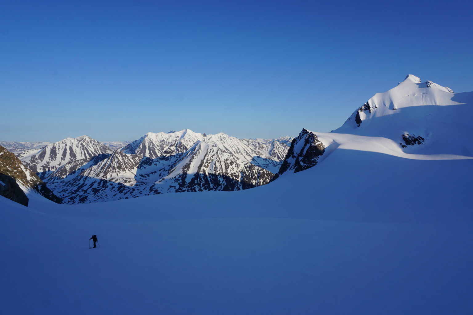 Hiking away from Tvillingtinden with our snowboard tracks on the peak