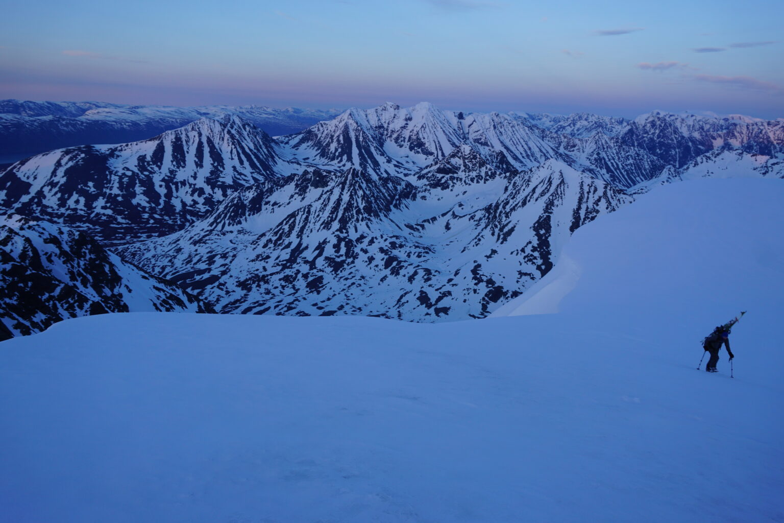 Climbing to the top of Tafeltinden at sunset with the Northern Lyngen Alps in the background