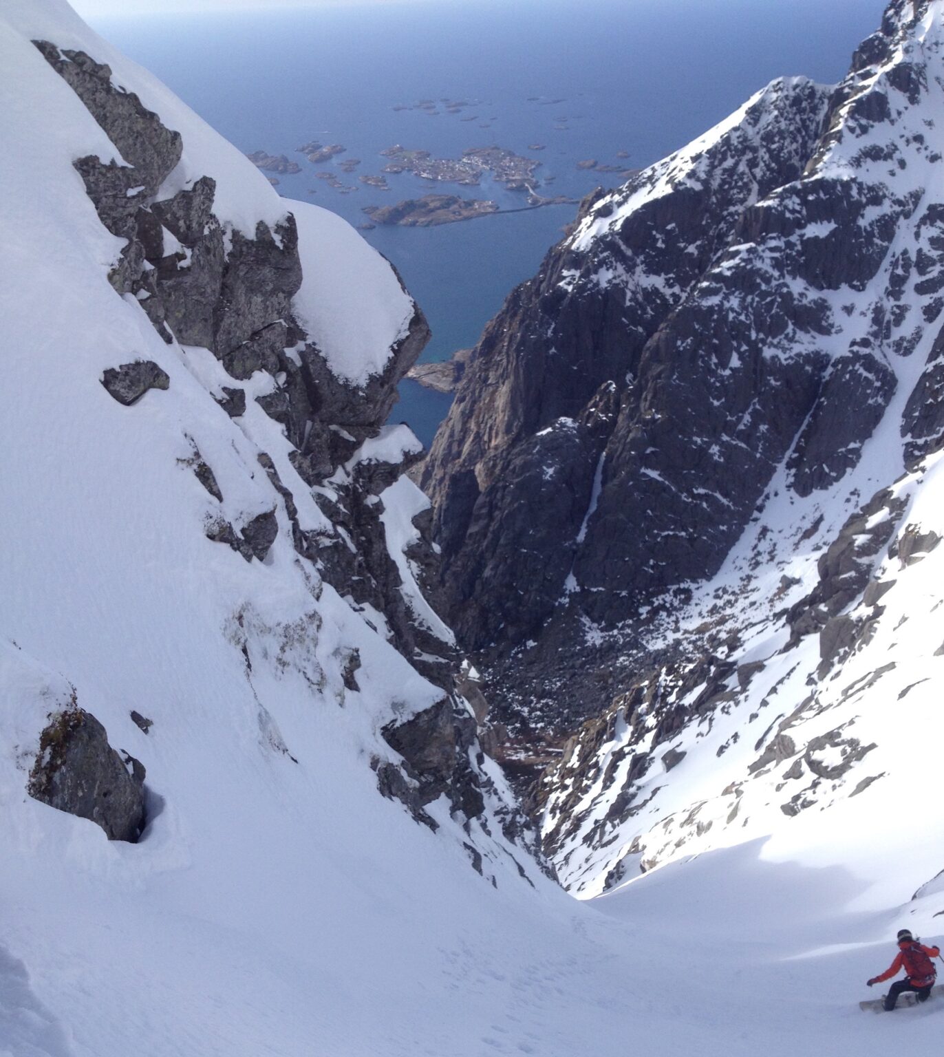 Snowboarding down Vågakallen South Couloir in the Lofoten Islands of Norway