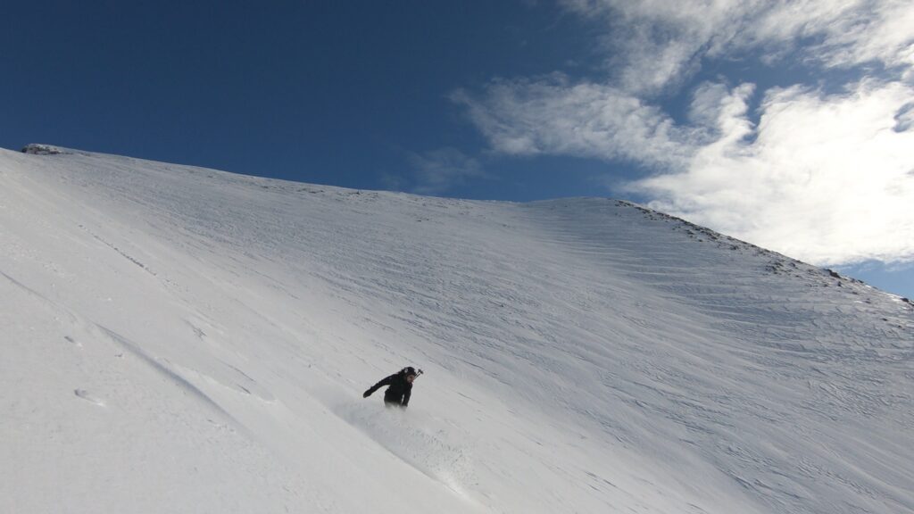 Snowboarding down a west face in the Kukisvumchorr Backcountry