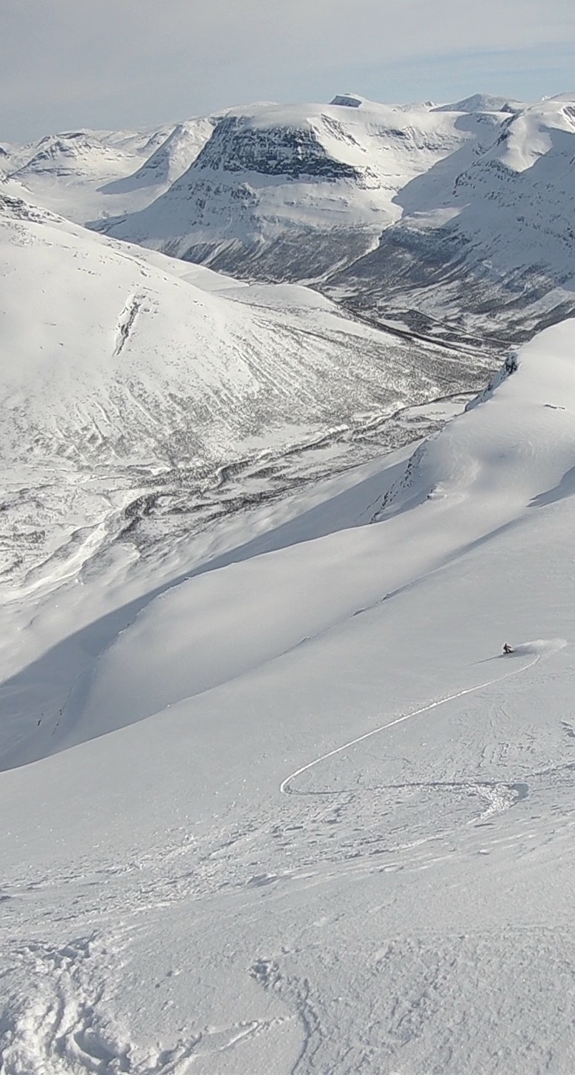 Making powder turns while snowboarding down Blåbærfjellet Northeast Bowl