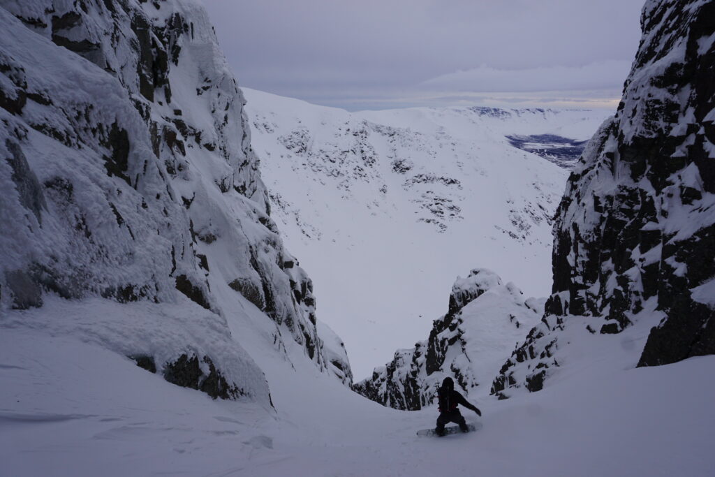 snowboarding down a steep couloir on Mount Aikuaivenchorr