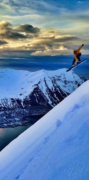 Snowboarding off the summit of Hestskarðshnjúkur near Siglufjörður