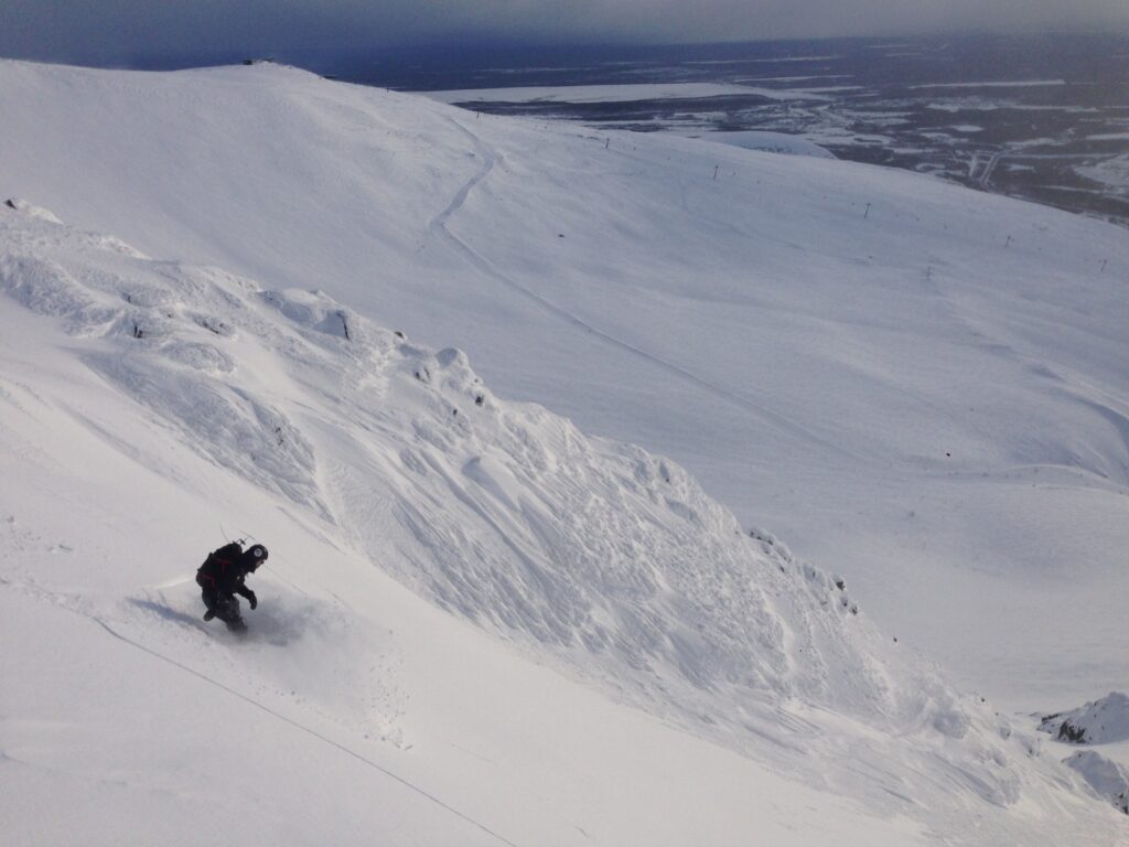 Snowboarding down a couloir in the Bigwood sidecountry