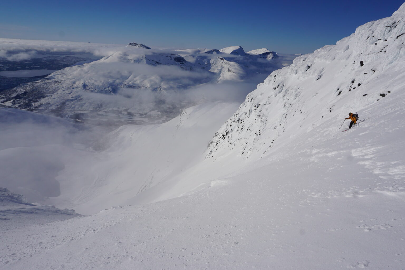 Skiing into Istinden East Bowl from the high col