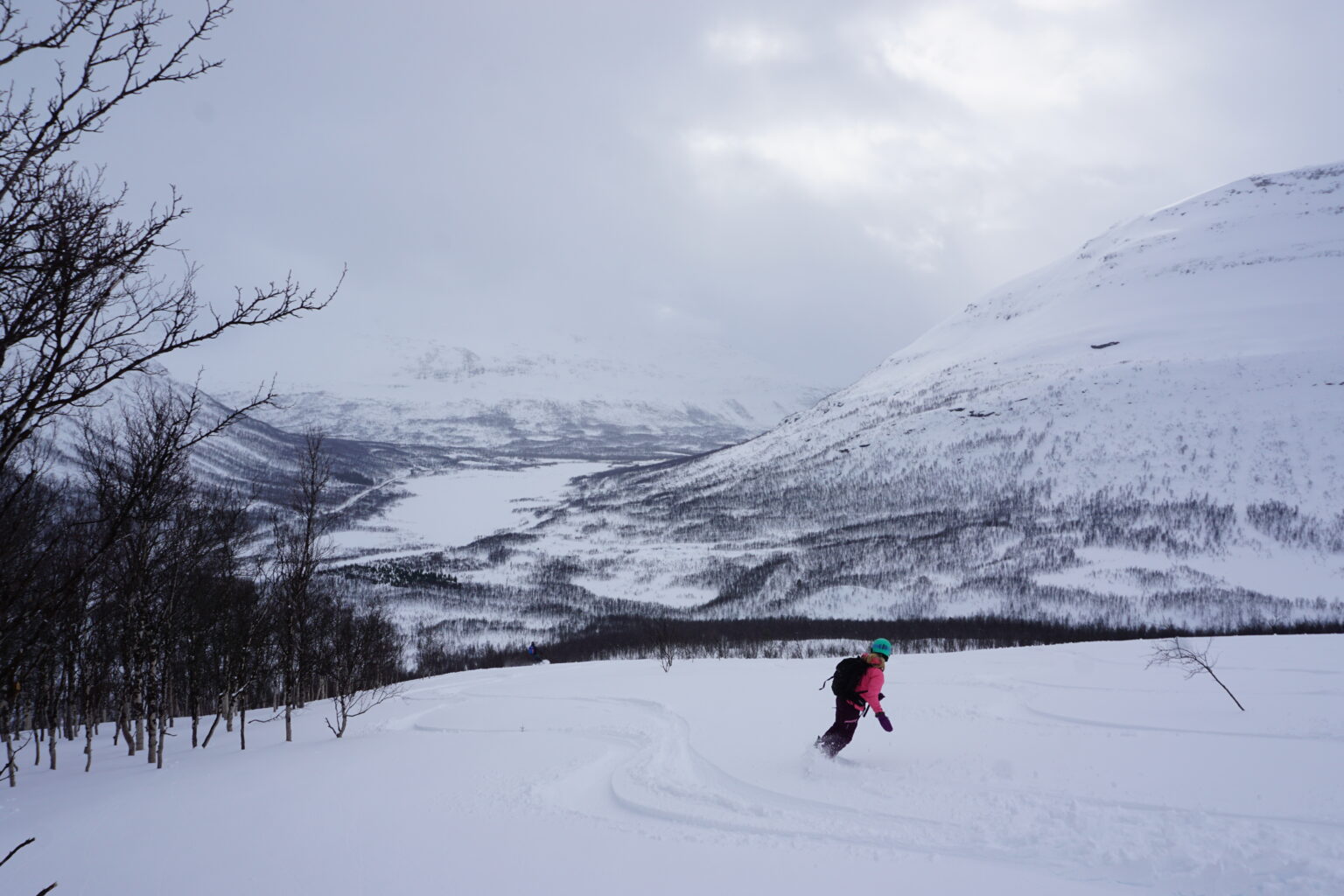 Snowboarding with the Tamokdalen Valley in the distance