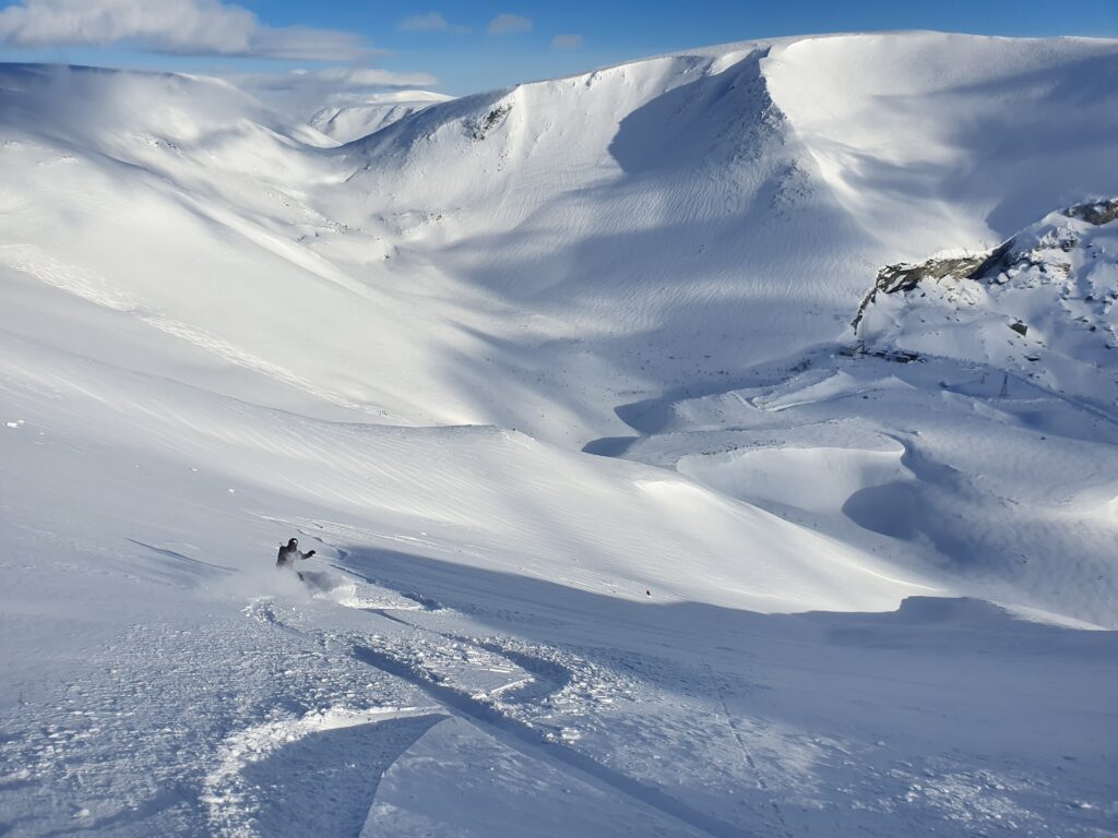 Ilkka crossing Bens tracks snowboarding in the sidecountry of 25 km ski center