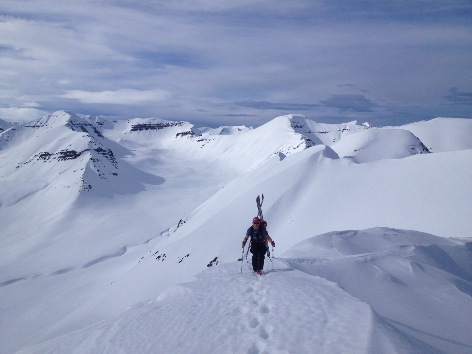 Climbing onto the ridge of Arnfinnsfjall with the northern mountain of Iceland in the distance