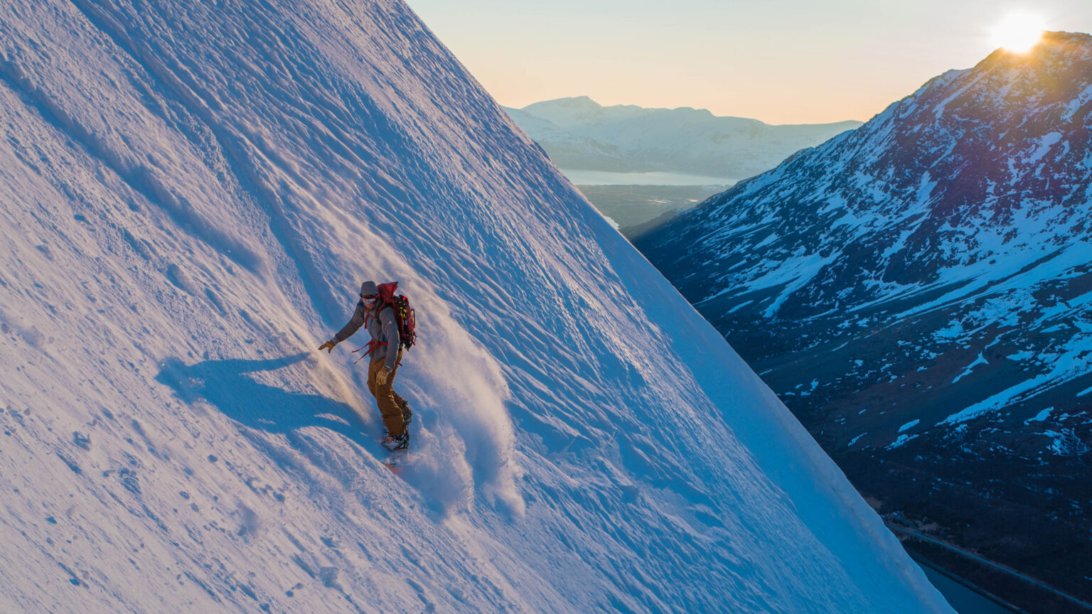 Snowboarding down the North Couloir of Rornestinden in the Lyngen Alps of Norway