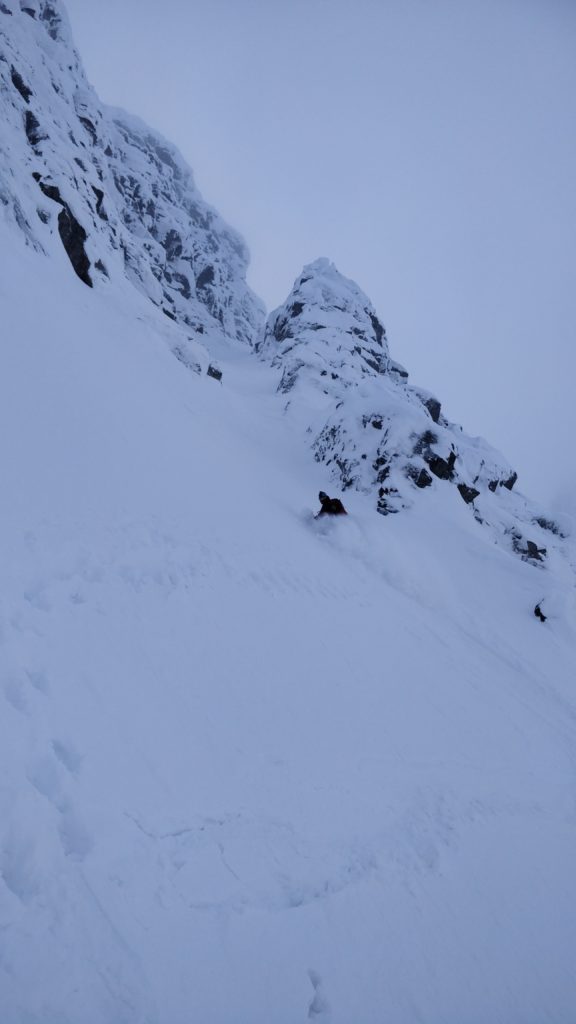 Snowboarding down the lower section of Tahtarvumchorr Ridge couloir