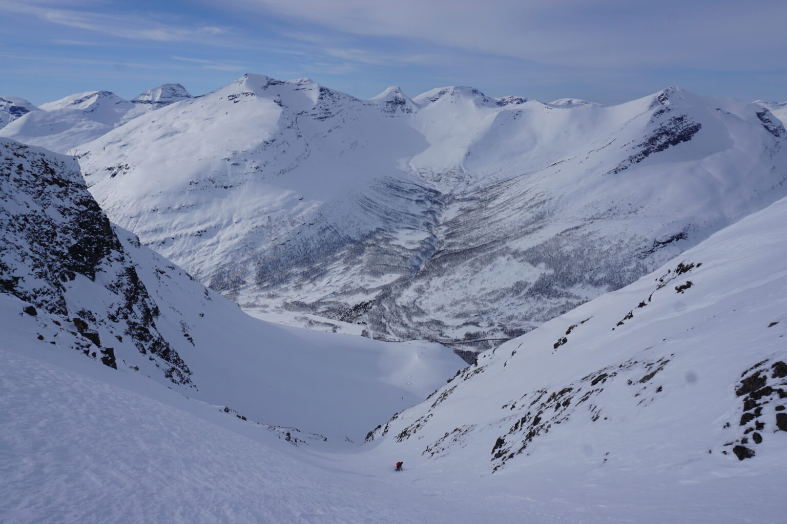 Snowboarding down Tamokfjellet North chute with the Tamokdalen backcountry in the distance